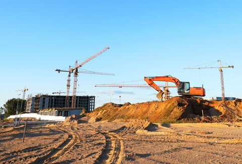 Construction site with excavator and cleared land ready for building foundation